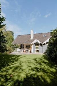 a white house with a lawn in front of it at An Intimate Get-Away By The Sandvig Bay in Haderslev