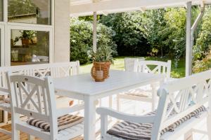 a white table and chairs on a porch at An Intimate Get-Away By The Sandvig Bay in Haderslev +9 photos