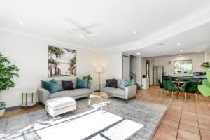 a living room with two couches and a table at Byron Beachside 2 in Byron Bay