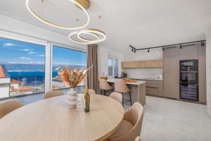 eine Küche und ein Esszimmer mit Tisch und Stühlen in der Unterkunft Holiday house with a swimming pool Vrbnik, Krk - 24526 in Vrbnik