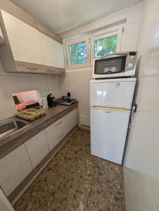 a small kitchen with a white refrigerator and a microwave at Holiday home in Siofok - Balaton 53215 in Siófok