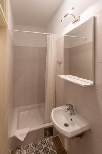 a white bathroom with a sink and a mirror at Apartments by the sea Zivogosce - Blato, Makarska - 24667 in Podgora