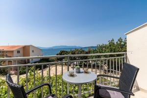 a balcony with a table and chairs and the ocean at Apartments by the sea Zivogosce - Blato, Makarska - 24667 in Podgora