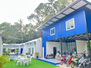 a blue house with motorcycles parked in front of it at MJOY Resort in Taling Ngam Beach +11 photos