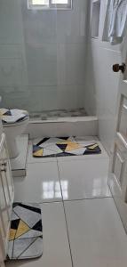 a bathroom with a toilet and a rug on the floor at Eden Cove Villa in Montego Bay