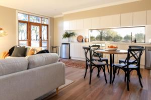 a living room with a couch and a table with chairs at Highgrove Studio - in the Vineyards in Eurunderee