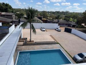 a swimming pool on the roof of a house with a palm tree at Cubo Hotel - Rio Branco in Rio Branco