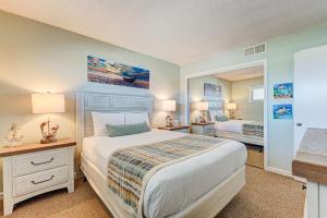 a bedroom with a large bed and a mirror at 1112 Relax Life Is Good by Atlantic Towers in Carolina Beach