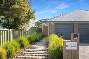 a house with a sign that says sell houses at Beachstay Hideaway Vincentia by Book Jervis Bay in Vincentia