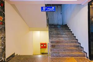 a staircase in a building with a blue sign at Super Hotel O Botcha Convection in Visakhapatnam