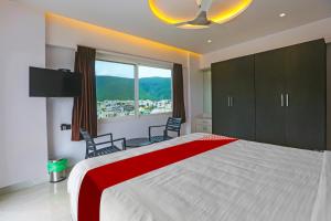 a bedroom with a large bed and a large window at Super Hotel O Botcha Convection in Visakhapatnam