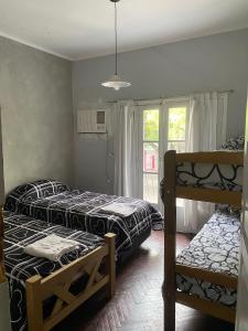 メンドーサにあるHOSTAL HOUSE REYMON,habitaciones privadas" precio por persona"のベッド2台と窓のある寝室