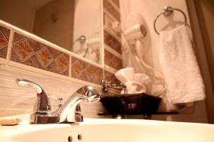 lavabo con grifo y espejo en Hotel Los Altos Esteli, en Estelí