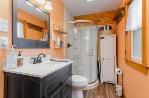 a bathroom with a sink and a toilet and a mirror at Acorn Cottage at Hocking Vacations in Logan +16 photos