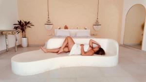 a woman is laying on a bed at ALMA BONITA walking distance to the beach in Gili Air