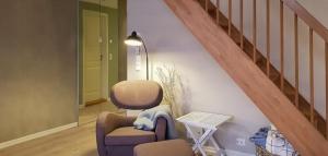 un soggiorno con sedia e scala di Seaside Dream Cabin With Jacuzzi a Steinsland Altre 19 foto