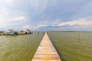 a wooden dock in the middle of a body of water at Wolf Bay Villas in Orange Beach