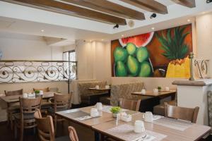 a restaurant with tables and chairs and a painting on the wall at Hotel San Marcos Express in Culiacán