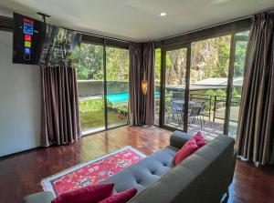 a living room with a sectional couch and a television at Xscape Tambun in Ipoh