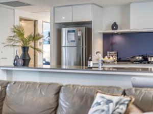 Una sala de estar con un sofá y una cocina. en 2BR Unit Heart of Surfers Paradise - Spa, Pool, en Gold Coast 36 fotos más