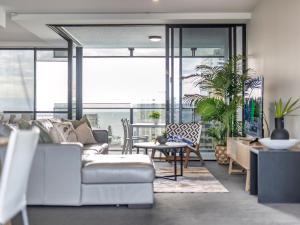 una sala de estar con un sofá y una mesa en 2BR Unit Heart of Surfers Paradise - Spa, Pool, en Gold Coast