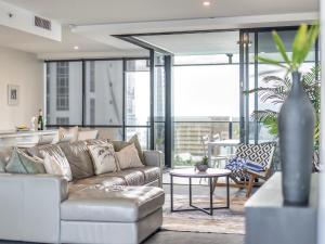 una sala de estar con un sofá y una mesa en 2BR Unit Heart of Surfers Paradise - Spa, Pool, en Gold Coast