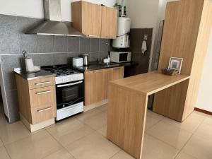 a kitchen with wooden cabinets and a stove top oven at Departamento de 2 dormitorios in Venado Tuerto