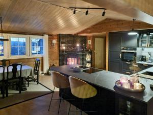 a kitchen with a large island with a table and chairs at Family Cabin With Stunning Views At Sjusjøen in Eggedal