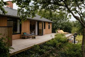 a house with a wooden deck in the yard at Enjoy The Morning With A Dip In The Sea in Odder