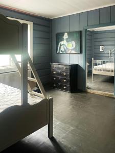 ein Schlafzimmer mit blauen Wänden, einem Etagenbett und einer Kommode in der Unterkunft Historic Old Rectory In The Heart Of Norway in Vestre Gausdal