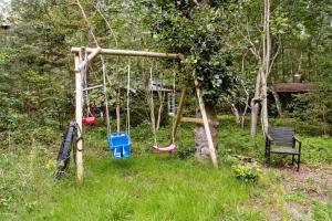 a swing set in a yard with a bench at Forest Vibe And Idyll On Møn in Stege