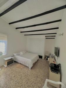 a bedroom with a bed and a desk and a television at Casa al lado de Multicentro in Ibagué