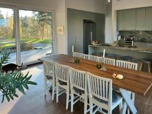 a kitchen with a long wooden table and chairs at Your Archipelago Dream On Ingarö in Värmdö