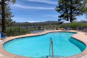 una grande piscina con sedie blu di Boulder Bear Lakeside Condo- Big Bear Modern Retreat a Big Bear Lake