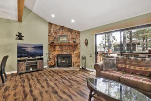 un soggiorno con divano e camino di Boulder Bear Lakeside Condo- Big Bear Modern Retreat a Big Bear Lake