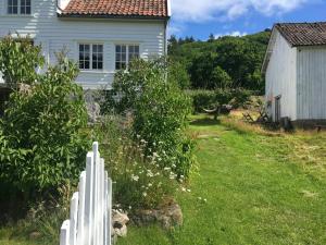 una cerca blanca frente a una casa en Idyllic Farmhouse From 1840 With Sea View In Spind, en Farsund