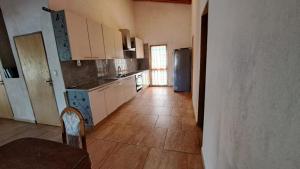 eine Küche mit weißen Schränken, einem Tisch und einem Kühlschrank in der Unterkunft Wall Apartamentos in Hohenau