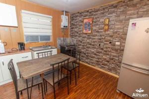 Una cocina con una mesa de madera y un refrigerador. en Arriendo cerca Puerto Varas, en Puerto Montt
