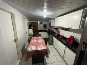a kitchen with a table with a red tablecloth on it at Casa para temporada Garanhuns - Natal Luz, Festival do vinho, Festival de inverno, Viva dominguinhos in Garanhuns