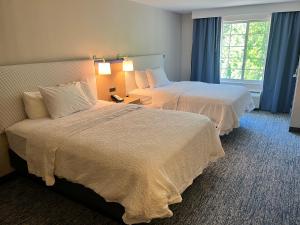 a hotel room with two beds and a window at Tapa Hotel, Inn & Suites in Mahwah +55 photos