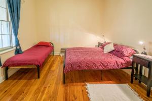 ein Schlafzimmer mit zwei Betten mit roten Decken und einem Holzboden in der Unterkunft Mount Wood Homestead 