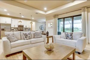 uma sala de estar com dois sofás e uma mesa em Sunny Tropicana Cape Coral em Cape Coral