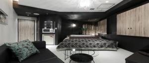 a bedroom with a bed and a couch at Hotel VARKIN in Tokyo