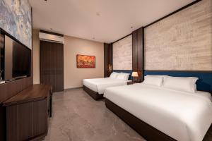una camera d'albergo con due letti e una TV a schermo piatto di Tam Coc Center Luxury Hotel & Villa a Ninh Binh Altre 43 foto
