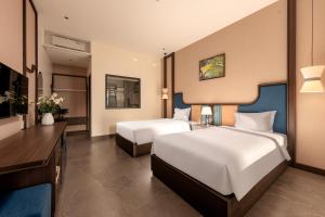 a hotel room with two beds and a television at Tam Coc Center Luxury Hotel & Villa in Ninh Binh