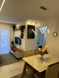 Apartamento Canto do Forte في برايا جراندي: غرفة معيشة مع طاولة وغرفة طعام