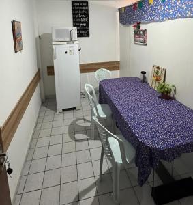 Il comprend une cuisine équipée d'une table violette et d'un réfrigérateur. dans l'établissement Apartamento no centro, à Campina Grande