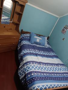 a bed in a room with a blue wall at Casa Familiar Equipada in Curacautín