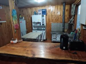 a kitchen with a table and a kitchen with a refrigerator at Casa Familiar Equipada in Curacautín +11 photos