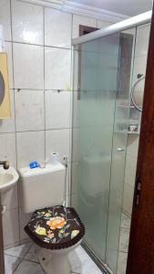 a bathroom with a toilet and a glass shower at casa km in Rio das Ostras